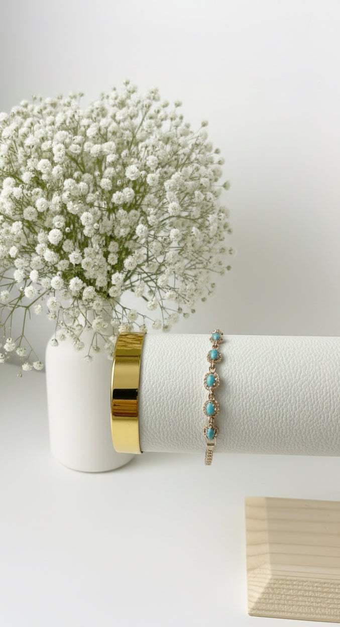 Türkis Armband mit goldenen Details auf weißem Schmuckständer.