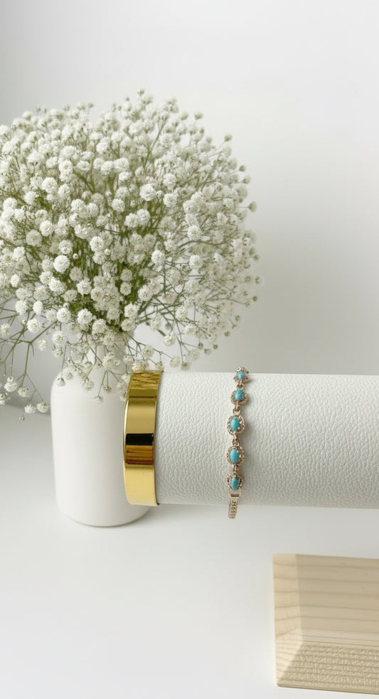 Türkis Armband mit goldenen Details auf weißem Schmuckständer.